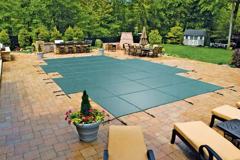 Pool with green winter safety cover, professional pool opening and closing in Maine
